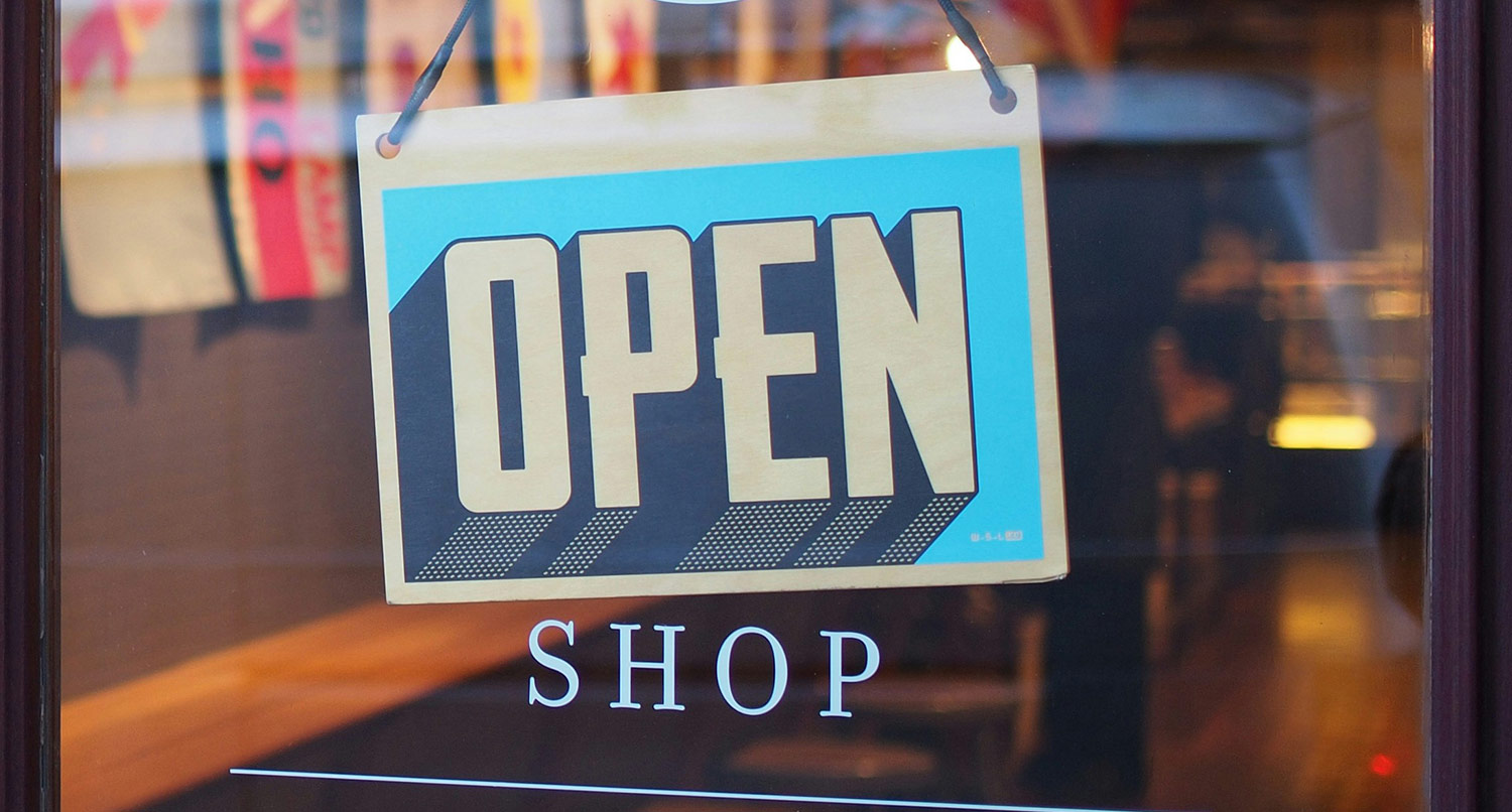 an open sign in the window of a small business